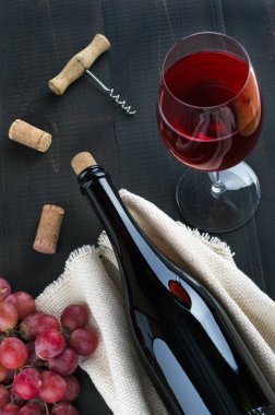 Şişe şarap, Şarap kadehi, üzüm ve tirbuşon karanlık backgr üzerinde