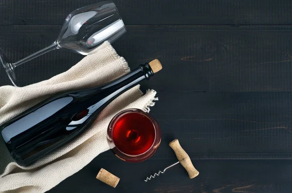 Bottle, wine glasses and corkscrew on dark  table. — Stock Photo, Image