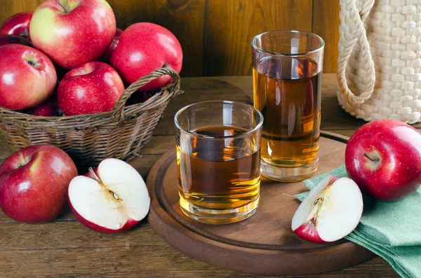 Zumo de manzana en vasos y manzanas rojas . — Foto de Stock