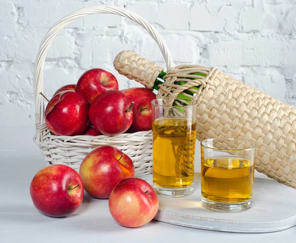 Яблука і сік в окулярах на білому столі . — стокове фото