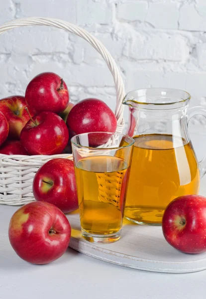 Яблучний сік в деканері і склянка з яблуками крупним планом на білому — стокове фото