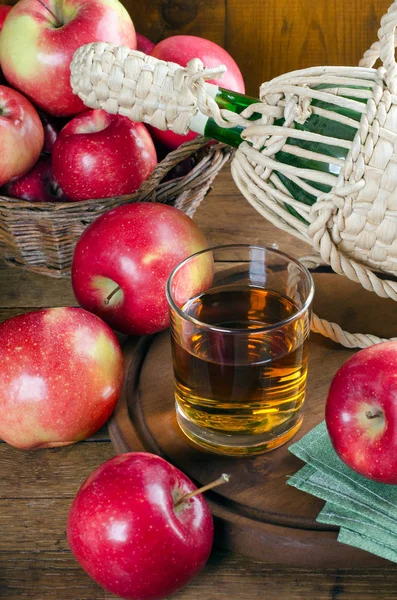 Apple juice in a glass, apples and bottle.