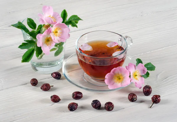 Квіти шипшини і чашка чаю — стокове фото