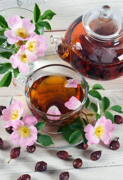 Kopp och tekanna te med höft ros blommor — Stockfoto