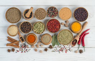 Beyaz ahşap arka planda renkli ve aromatik otlar ve baharatlar. Üst Manzara. Düz yatıyordu.