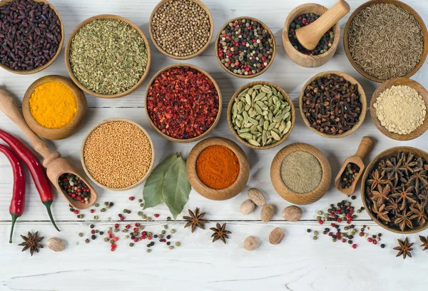 Beyaz ahşap masada yemek pişirmek için baharatlar ve baharatlar. Üst görünüm.