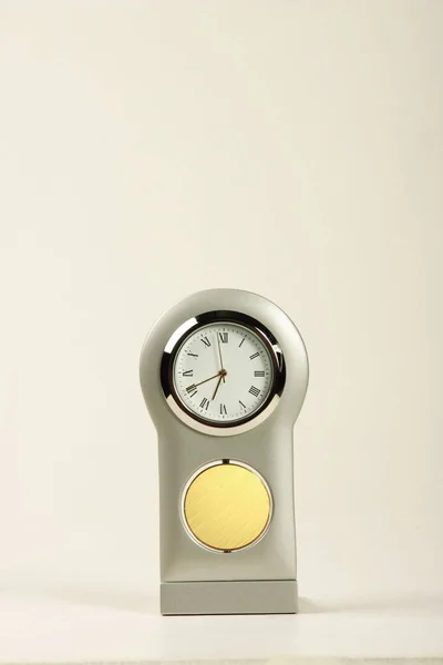 A desk clock with a metal area for promotion, branding, emblem or lettering.