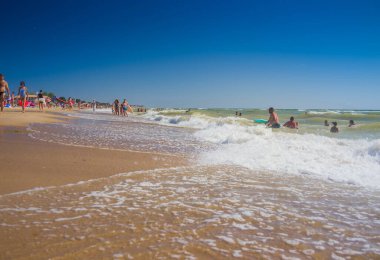 Ukrayna, Kyiv - 4 Ağustos 2020. Sıcak yaz günlerinde Ukrayna 'nın Hrybivka kentindeki plaj manzarası, Odessa yakınlarındaki turistler, güneşlikler ve şemsiyeler. Karadeniz