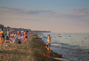 Ukrayna, Kyiv - 7 Ağustos 2020. Sıcak yaz günlerinde Ukrayna 'nın Hrybivka kentindeki plaj manzarası, Odessa yakınlarındaki turistler, güneşlikler ve şemsiyeler. Kasvetli deniz