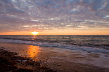 Bulutlu bir sabahta denizde güzel bir gün doğumu. Kumlu sahil şeridini bırakıyorum. Karadeniz. Sanzhiika. Ukrayna