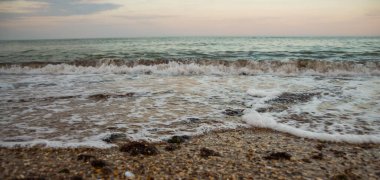 Akşamları deniz sahilinde güzel dalgalar. Deniz batımı. Deniz sahilinde gün batımı