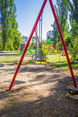 Yeşil ağaçlarla çevrili parktaki renkli çocuklar oyun parkı aktiviteleri