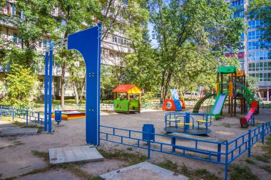 Yeşil ağaçlarla çevrili parktaki renkli çocuklar oyun parkı aktiviteleri