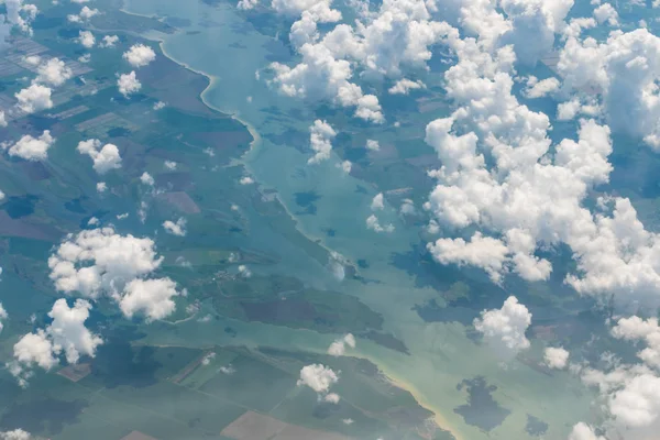 从河上的飞机，绿色的田野，云彩。云壁纸 — 图库照片