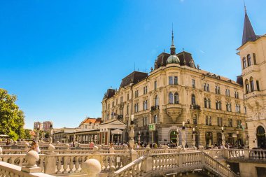 Ljubljana, Slovenia - 2013: Triple Bridge with Kresija Building in the background. On the right is Philip Mansion, together with Kresija Building forms the main entrance to the Old Town of Ljubljana clipart