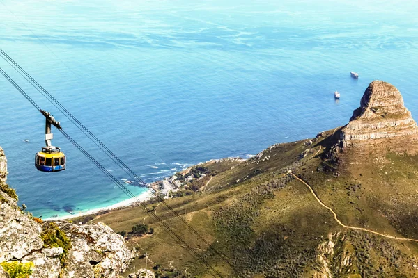 Bir teleferiğin Masa Dağı 'ndan aşağıya bakan manzarası sağda Aslan Kafası ve arka planda Atlantik Okyanusu.