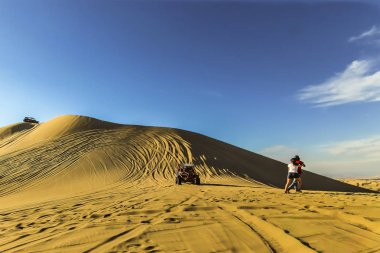 Turist bir kenara hareket olarak yamaç aşağı yarış kum Dune Buggy