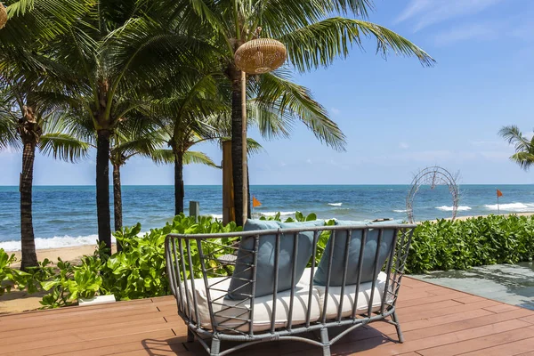 Un sofá de ratán al aire libre en una terraza frente a la playa — Foto de Stock