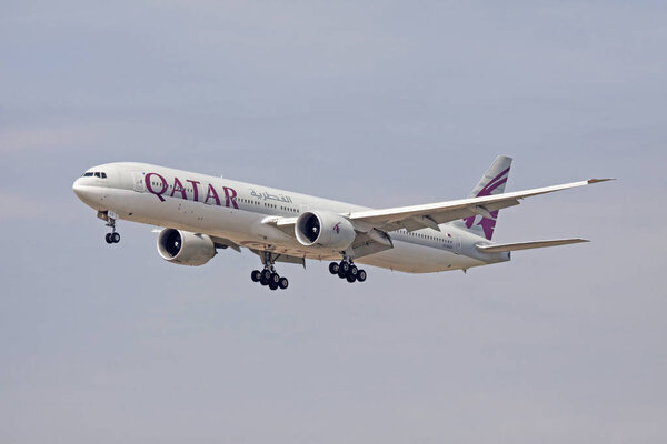 Gray and dark red triple boeing 777 from qatar airways, just left the runway for a trip to Doha