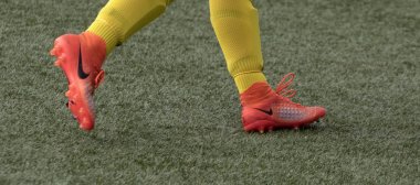 Amsterdam, Hollanda - 26 Nisan 2019: Ünlü marka nike'ın sarı çorapları ve turuncu futbol ayakkabılarıyla futbolcu bacaklarının yakın görünümü