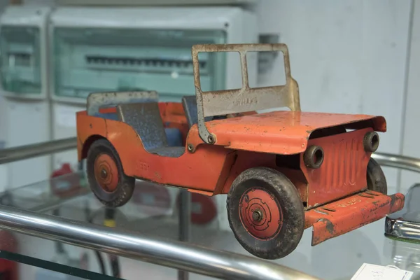 橙色金属儿童玩具车 玻璃上显示橡胶轮 — 图库照片