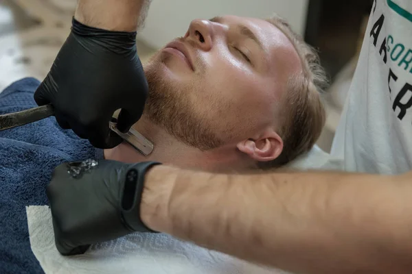 Bearded Male Sitting Armchair Barber Shop While Hairdresser Shaves His — Stock Photo, Image