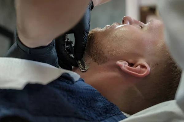 Bearded Male Sitting Armchair Barber Shop While Hairdresser Shaves His — Stock Photo, Image