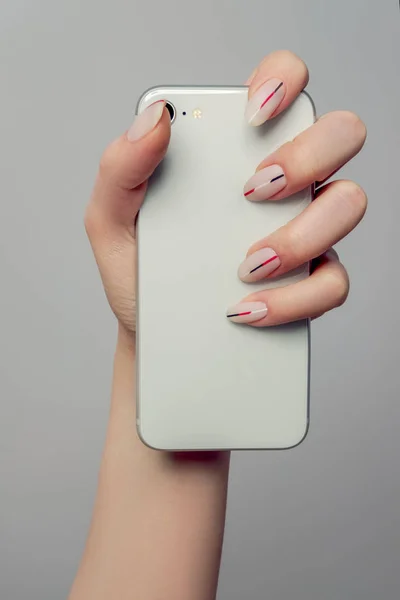 Phone in hand. Nails Design. Hands With with a matt minimalist manicure.  Close Up Of Female Hands With Trendy Nails on a light background. Art Nail. High Quality Image.
