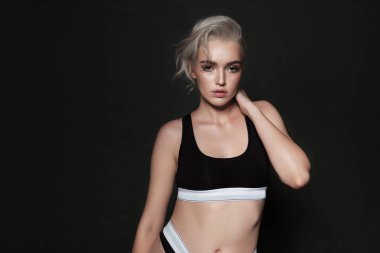 Güzel seksi sarışın spor unde karanlık bir arka plan üzerinde poz