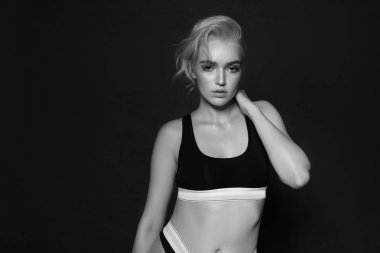 Güzel seksi sarışın spor unde karanlık bir arka plan üzerinde poz