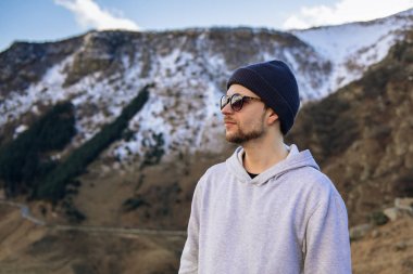 Karla kaplı zirvelerin arka planına karşı dağlarda gezgin. Kazbek Dağı, Gürcistan