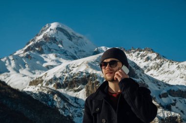 Dağlarda seyahat eden telefon görüşmeleri yapar