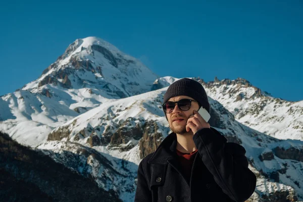 Путешественник в горах делает телефонные звонки — стоковое фото
