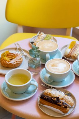 Cafe masa bardak kahve, eklerleri ve kek ile