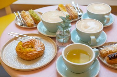 Cafe masa bardak kahve, eklerleri ve kek ile