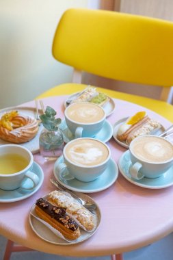 Cafe masa bardak kahve, eklerleri ve kek ile