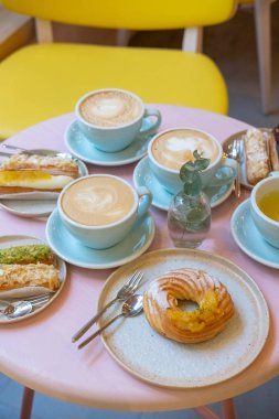 Cafe masa bardak kahve, eklerleri ve kek ile