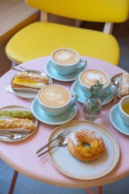 Cafe masa bardak kahve, eklerleri ve kek ile