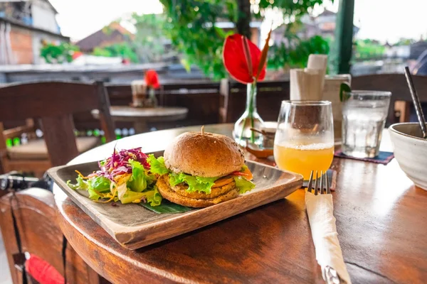 Papan dengan burger vegetarian lezat di atas meja kayu — Stok Foto