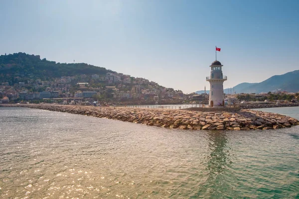 Blick auf Landschaft und Leuchtturm des alanya Hafens mit türkischer Flagge — kostenloses Stockfoto