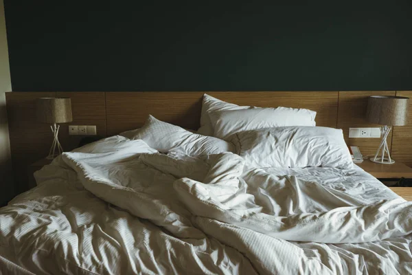 Crumpled bed in hotel room