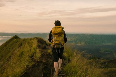 Sırt çantalı bir turist volkanda gün batımıyla karşılaşır. Turizm konsepti