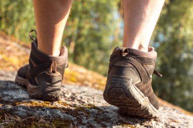 Yürüyüş ayakkabılı bacaklar. İskandinav dağlarında tek başına yürüyüş yapan bir adam. Aktif, sağlıklı yaşam tarzı macerası. Seyahat ve tatil kavramı