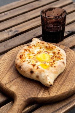Adjarian 'da Khachapuri ve bir bardak nar şarabı. Mozzarella ve yumurtalı açık turta. Gürcistan mutfağı.
