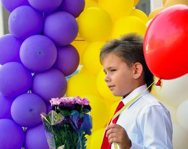 Krasnodar, Russia - September, 1 2014: Boy with a bouquet of flowers and a balloon became First Graders. First time to school
