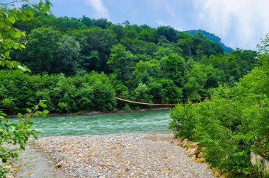 Fırtınalı dağ nehri üzerindeki asma köprü, Kuzey Kafkasya