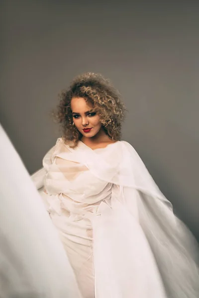 Elegante Krullend Vrouw Witte Chiffon Jurk Grijze Achtergrond — Stockfoto