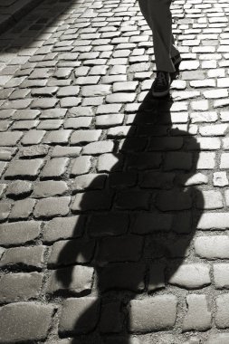 Gölge cobblestones arka ışık içinde yaklaşmakta olan kişilerin 
