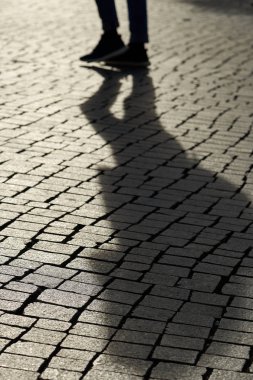 Arka ışık yılında Leipzig şehir merkezinde bir yaya gölgesi                               
