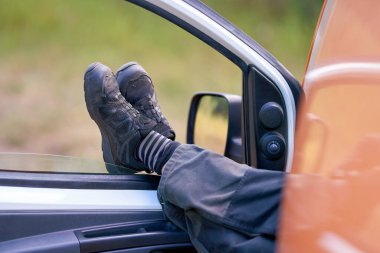    İş kıyafetleri içinde bir işçi arabasında mola veriyor.                             